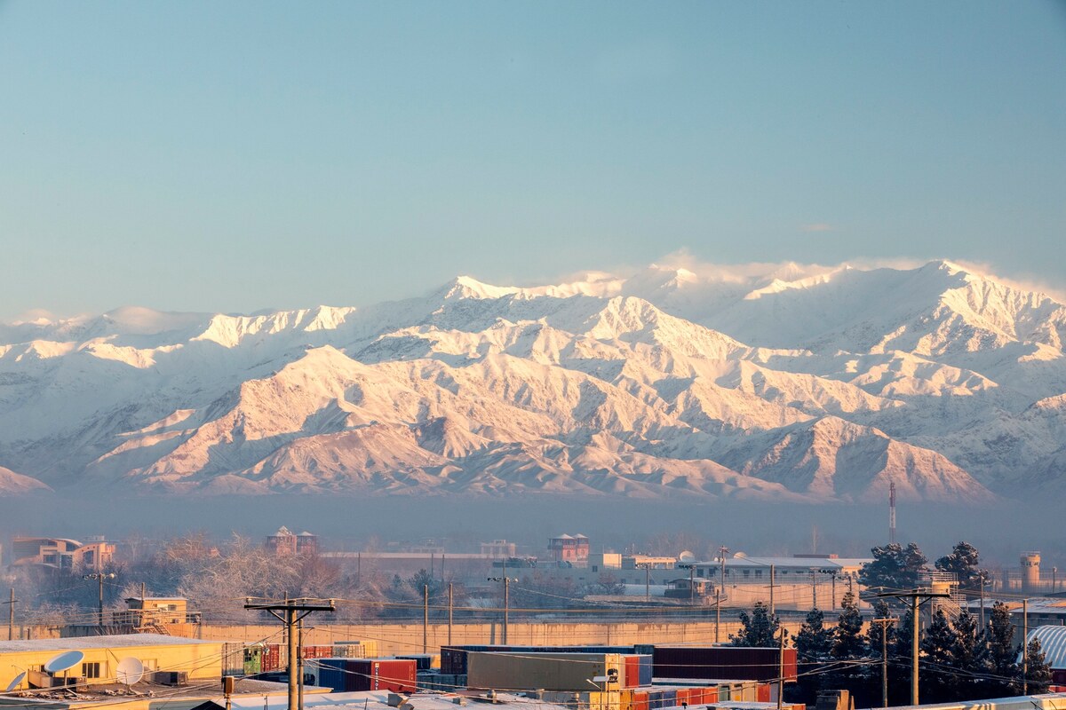 Container yards and buildings at Bagram Airfield, Afghanistan, beneath the snow-capped Hindu Kush