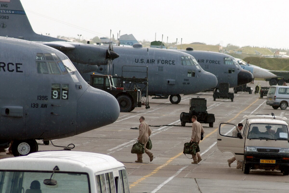 U.S. Air Force C-130 aircraft and troops with gear on the austere flight line at Karshi-Khanabad, Uzbekistan