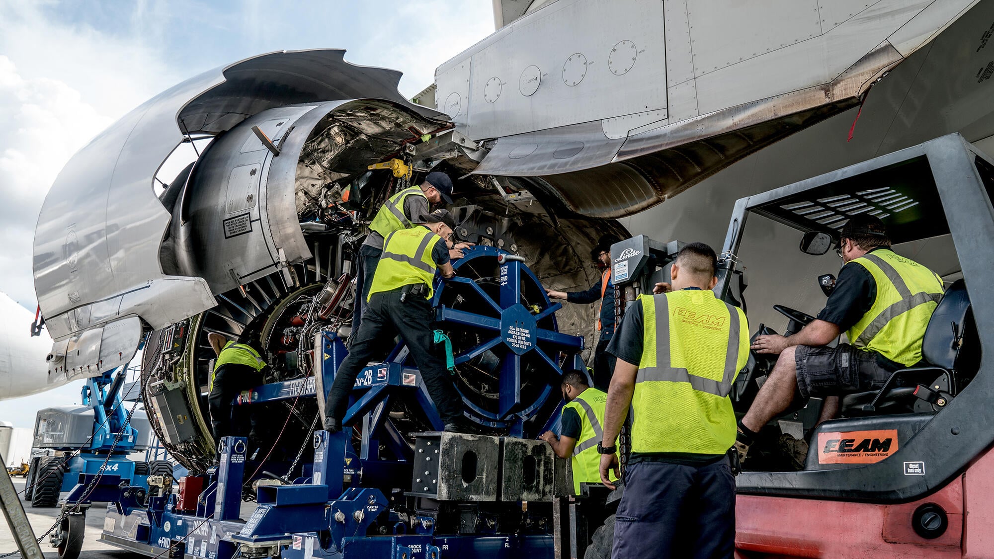 Military and civilian aviation maintenance workers near a flight line