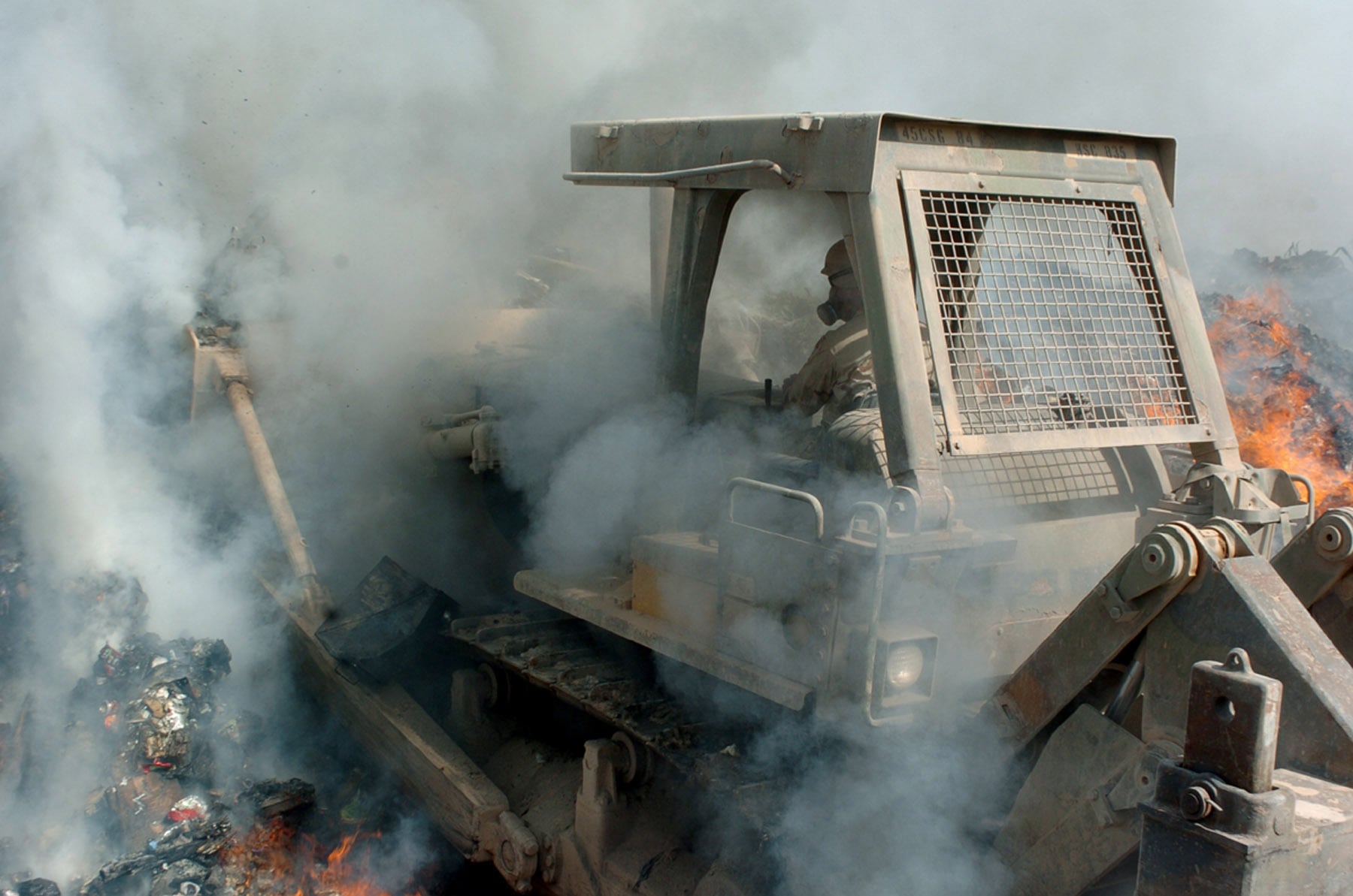 Post-9/11 service members near a burn pit plume at a forward operating base